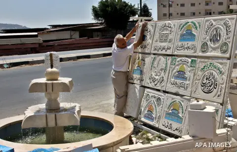 A Palestinian man displays the stones carved out of rock and painted it the Dome of the Rock in order to sell it, in the West Bank City of Nablus, on Aug. 27, 2012. Photo by Nedal Eshtayah