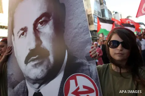 A Palestinian supporter of the Palestinian Front for the Liberation of Palestine (PFLP) holds a picture of the PFLP leader Abu Ali Mustafa during a rally mark the 11th anniversary of assassinate him, in the West Bank cit...