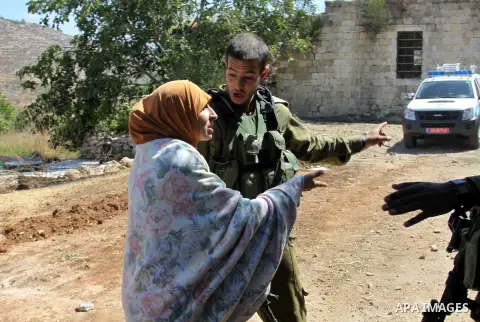 Israeli soldiers try to stop Palestinian woman while she tries to reach her home after Jewish settlers from the Israeli settlement of Livona attacked her familly house at Al - Loban Village near the west Bank City of Nab...