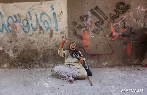 An elderly Palestinian woman sits on the ground outside her home at Al-Shati refugee camp in Gaza City on August 28, 2012. Life in the poor and crowded Gaza Strip is going to get harsher still unless action is taken now,...