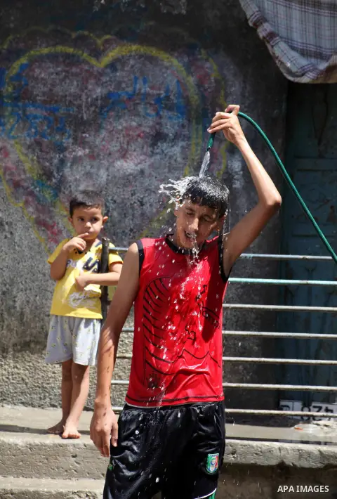 A Palestinian boy enjoys himself with water during hot weather at Al-Shati refugee camp in Gaza City on August 28, 2012. Life in the poor and crowded Gaza Strip is going to get harsher still unless action is taken now, a...