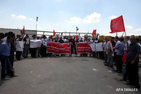 Palestinian protesters hold signs during a demonstration in solidarity with Palestinian prisoners being held in Israeli jails, outside the Ofer military prison, near the West Bank city of Ramallah, on August 28, 2012. Ph...