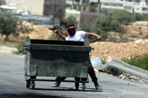 A Palestinian protester throws stones at Israeli soldiers outside the Ofer military prison, near the West Bank city of Ramallah, on August 28, 2012, during a demonstration in solidarity with Palestinian prisoners being h...