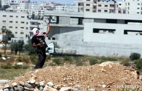 A Palestinian protester throws stones at Israeli soldiers outside the Ofer military prison, near the West Bank city of Ramallah, on August 28, 2012, during a demonstration in solidarity with Palestinian prisoners being h...