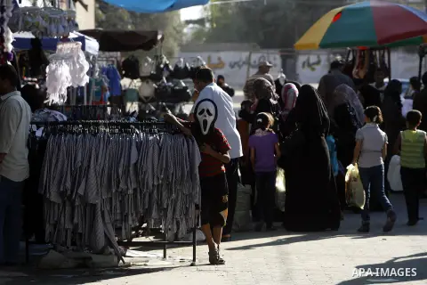 A Palestinian boy wears a mask and sells school uniforms at Rafah's market in the southern Gaza strip on Aug 28, 2012. Next Sunday the First day for the new school year according to Palestinian Ministry of Education in t...