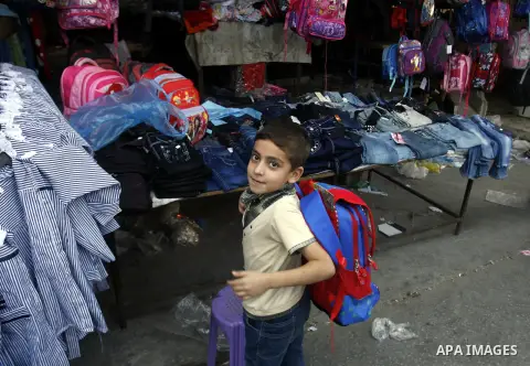 A Palestinian boy carry his new school bag at Rafah's market in the southern Gaza strip on Aug 28, 2012. Next Sunday the First day for the new school year according to Palestinian Ministry of Education in the Gaza strip...