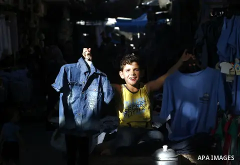 A Palestinian boy sells school uniforms at Rafah's market in the southern Gaza strip on Aug 28, 2012. Next Sunday the First day for the new school year according to Palestinian Ministry of Education in the Gaza strip and...