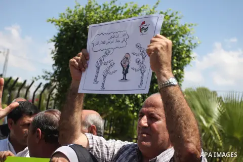 A Palestinian protester holds a sign during a demonstration against the the high expenses of Palestinian Prime Minister Salam Fayad, outside the office of the Presidency of the Government, in the West Bank city of Ramall...