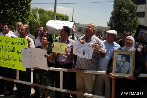 Palestinian protesters hold signs during a demonstration against the the high expenses of Palestinian Prime Minister Salam Fayad, outside the office of the presidency of the government, in the West Bank city of Ramallah,...
