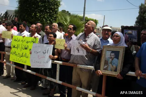 Palestinian protesters hold signs during a demonstration against the the high expenses of Palestinian Prime Minister Salam Fayad, outside the office of the presidency of the government, in the West Bank city of Ramallah,...