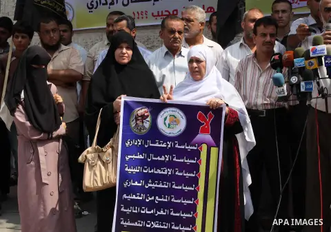 Palestinians hold up signs during a protest against administrative detention of Palestinian prisoners In Israeli jails, in front of the Red Cross headquarters in Gaza City on Aug. 29, 2012. Photo by Ashraf Amra