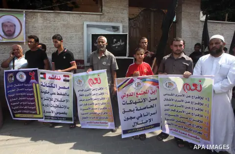 Palestinians hold up signs during a protest against administrative detention of Palestinian prisoners In Israeli jails, in front of the Red Cross headquarters in Gaza City on Aug. 29, 2012. Photo by Ashraf Amra