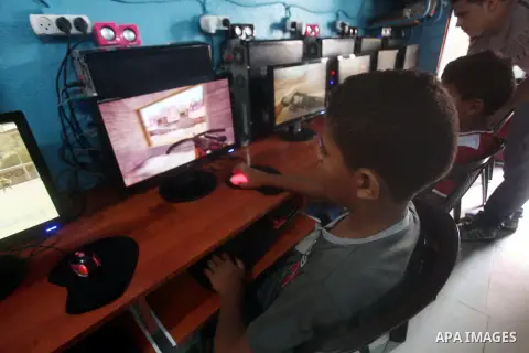 Palestinian children play computer games in a video game club, four days before the beginning of new school year in Gaza city, on Aug 29, 2012. Next Sunday the First day for the new school year according to Palestinian M...