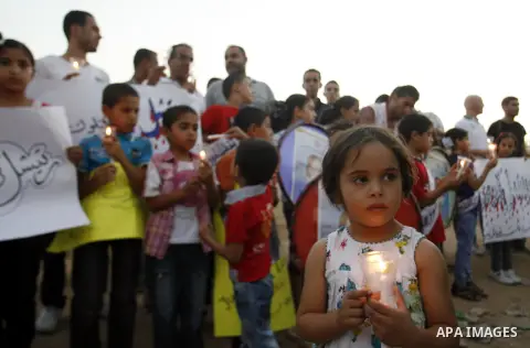 Palestinian children hold candles during a protest in Rafah in the southern Gaza Strip, against an Israeli court's ruling, August 29, 2012. The Israeli court on Tuesday cleared Israel's military of any blame for the deat...