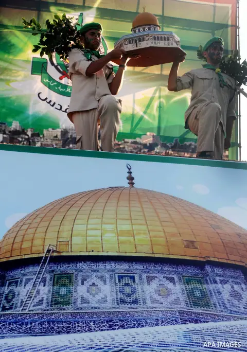 Palestinian boy scouts carry statues of the Dome of the Rock mosque during a festival entitled "Jerusalem in our eyes" organized by Hamas movement, marking the 43rd anniversary of burning down al-Aqsa mosque in Gaza city...
