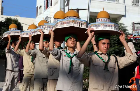 Palestinian boy scouts carry statues of the Dome of the Rock mosque during a festival entitled "Jerusalem in our eyes" organized by Hamas movement, marking the 43rd anniversary of burning down al-Aqsa mosque in Gaza city...