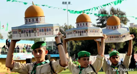Palestinian boy scouts carry statues of the Dome of the Rock mosque during a festival entitled "Jerusalem in our eyes" organized by Hamas movement, marking the 43rd anniversary of burning down al-Aqsa mosque in Gaza city...