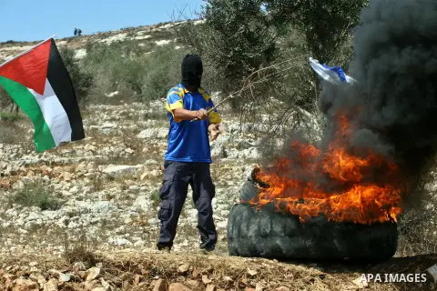 Palestinian protesters set fire the Israeli flag during clashes against the expropriation of Palestinian land by Israel in the village of Kafr Qaddum, near the West Bank city of Nablus on August 31, 2012, 2012. Photo by...