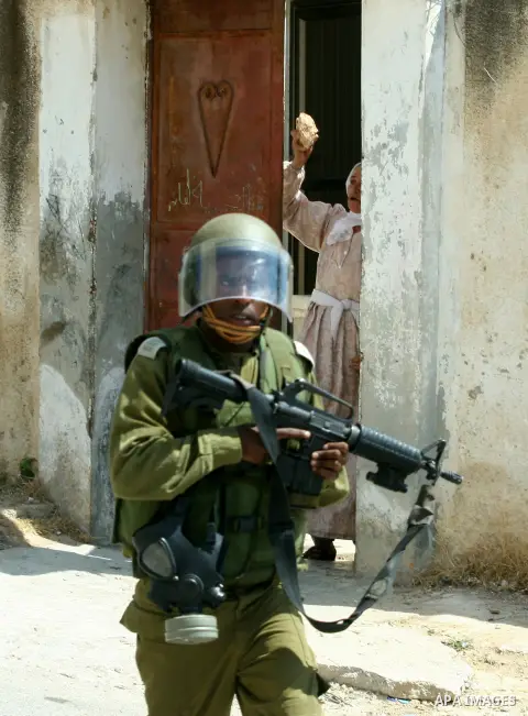 Palestinian woman attacks Israeli soldiers during clashes against the expropriation of Palestinian land by Israel in the village of Kafr Qaddum, near the West Bank city of Nablus on August 31, 2012. Photo by Nedal Eshtay...