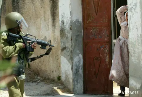 Palestinian woman attacks Israeli soldiers during clashes against the expropriation of Palestinian land by Israel in the village of Kafr Qaddum, near the West Bank city of Nablus on August 31, 2012. Photo by Nedal Eshtay...