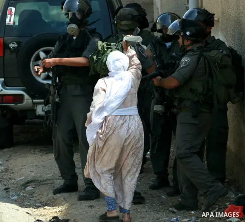 Palestinian woman attacks Israeli soldiers using her shoes during clashes against the expropriation of Palestinian land by Israel in the village of Kafr Qaddum, near the West Bank city of Nablus on August 31, 2012. Photo...