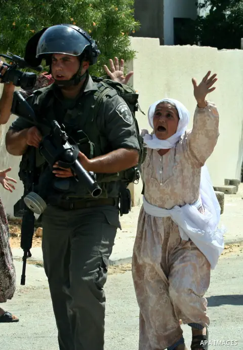 Palestinian woman attacks Israeli soldiers during clashes against the expropriation of Palestinian land by Israel in the village of Kafr Qaddum, near the West Bank city of Nablus on August 31, 2012. Photo by Nedal Eshtay...