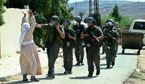 Palestinian woman attacks Israeli soldiers during clashes against the expropriation of Palestinian land by Israel in the village of Kafr Qaddum, near the West Bank city of Nablus on August 31, 2012. Photo by Nedal Eshtay...