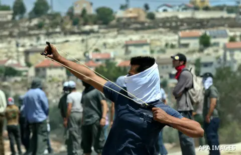 Palestinian protesters throw stones towards Israeli soldiers during clashes against the expropriation of Palestinian land by Israel in the village of Kafr Qaddum, near the West Bank city of Nablus on August 31, 2012. Pho...