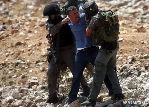 Israeli soldiers detain a demonstrator during clashes during a protest against the expansion of the nearby Jewish settlement of Halamish, in the West Bank village of Nabi Saleh, near Ramallah, Friday,August 31, 2012. Pho...