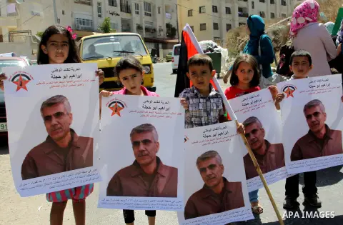Palestinian children hold portraits of Palestinian prisoner Ibrahim Abu Hijleh, outside the Red Cross building in the West Bank city of Nablus on Sep. 01, 2012. as they protest against Israel's policy of administrative d...