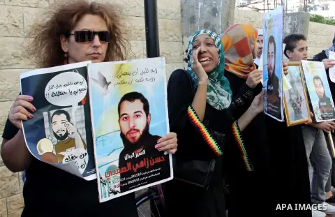 Palestinian protesters hold up banners and portraits of a prisoners jailed in Israel On hunger strike,during a rally in solidarity with prisoners in Israeli jails, in the West Bank city of Nablus on sep 1, 2012. Photo by...