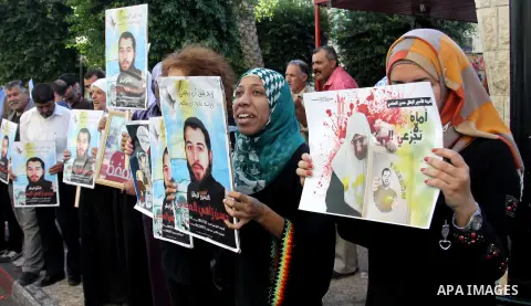 Palestinian protesters hold up banners and portraits of a prisoners jailed in Israel On hunger strike,during a rally in solidarity with prisoners in Israeli jails, in the West Bank city of Nablus on sep 1, 2012. Photo by...