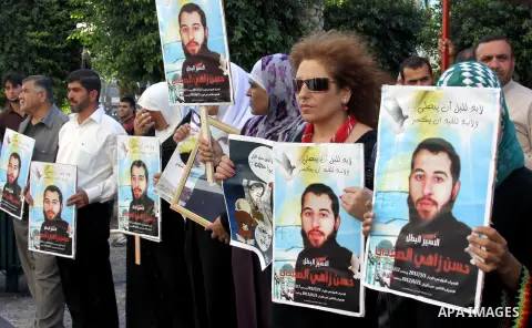 Palestinian protesters hold up banners and portraits of a prisoners jailed in Israel On hunger strike,during a rally in solidarity with prisoners in Israeli jails, in the West Bank city of Nablus on sep 1, 2012. Photo by...