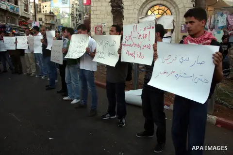 Palestinian protesters hold signs during a demonstration against the price rises, in the West Bank city of Ramallah, on September 02, 2012. Photo by Issam Rimawi