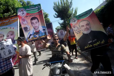 Palestinians hold a placard depicting jailed relatives during a protest in Gaza City calling for the release of Palestinian prisoners from Israeli jails September 3, 2012. Photo by Ashraf Amra