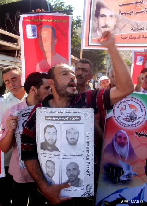 Palestinians hold a placard depicting jailed relatives during a protest in Gaza City calling for the release of Palestinian prisoners from Israeli jails September 3, 2012. Photo by Ashraf Amra