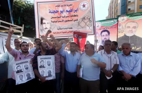 Palestinians hold a placard depicting jailed relatives during a protest in Gaza City calling for the release of Palestinian prisoners from Israeli jails September 3, 2012. Photo by Ashraf Amra