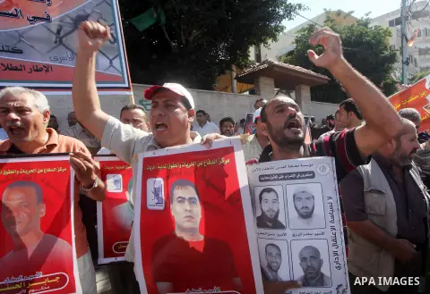 Palestinians hold a placard depicting jailed relatives during a protest in Gaza City calling for the release of Palestinian prisoners from Israeli jails September 3, 2012. Photo by Ashraf Amra