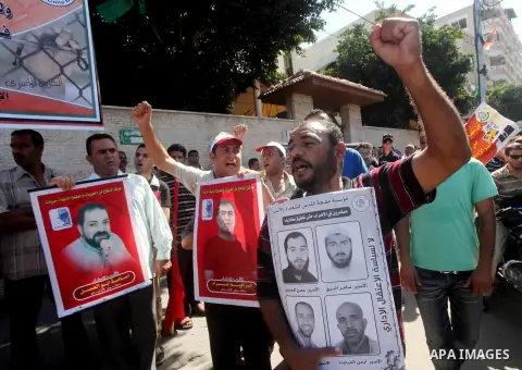 Palestinians hold a placard depicting jailed relatives during a protest in Gaza City calling for the release of Palestinian prisoners from Israeli jails September 3, 2012. Photo by Ashraf Amra