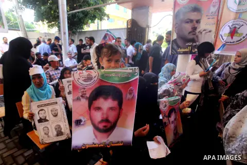 Palestinians hold a placard depicting jailed relatives during a protest in Gaza City calling for the release of Palestinian prisoners from Israeli jails September 3, 2012. Photo by Ashraf Amra