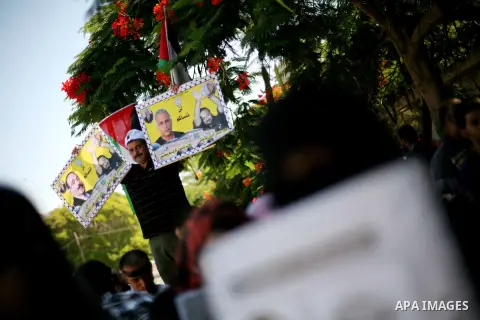 Palestinians hold a placard depicting jailed relatives during a protest in Gaza City calling for the release of Palestinian prisoners from Israeli jails September 3, 2012. Photo by Ashraf Amra