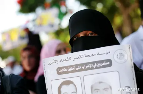 Palestinians hold a placard depicting jailed relatives during a protest in Gaza City calling for the release of Palestinian prisoners from Israeli jails September 3, 2012. Photo by Ashraf Amra