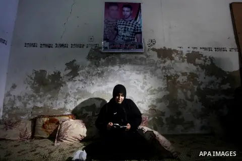 Palestinian Nadia Abu Nada holds a picture of her son Ihab Abu Nada at her home in the Shati refugee camp in Gaza City, Monday, Sept. 4, 2012. The death of a young Gaza man who set himself on fire because he could not fi...