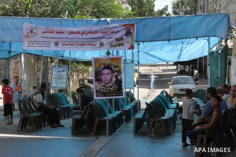 Palestinians sit in the mourning tent of Ihab Abu Nada in the Shati refugee camp in Gaza City, Monday, Sept. 3, 2012. The death of a young Gaza man who set himself on fire because he could not find a job has sent shockwa...