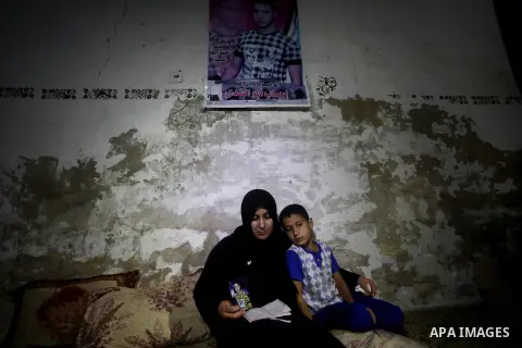 Palestinian Nadia Abu Nada holds a picture of her son Ihab Abu Nada at her home in the Shati refugee camp in Gaza City, Monday, Sept. 3, 2012. The death of a young Gaza man who set himself on fire because he could not fi...