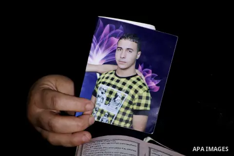 Palestinian Nadia Abu Nada holds a picture of her son Ihab Abu Nada at her home in the Shati refugee camp in Gaza City, Monday, Sept. 3, 2012. The death of a young Gaza man who set himself on fire because he could not fi...