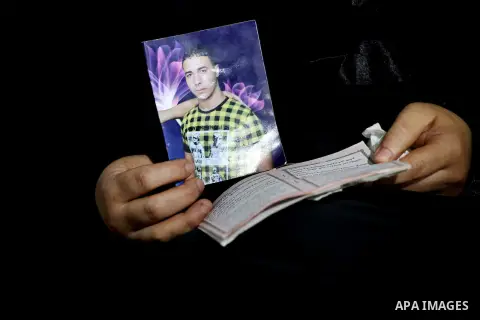 Palestinian Nadia Abu Nada holds a picture of her son Ihab Abu Nada at her home in the Shati refugee camp in Gaza City, Monday, Sept. 3, 2012. The death of a young Gaza man who set himself on fire because he could not fi...