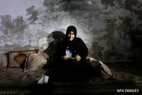 Palestinian Nadia Abu Nada holds a picture of her son Ihab Abu Nada at her home in the Shati refugee camp in Gaza City, Monday, Sept. 3, 2012. The death of a young Gaza man who set himself on fire because he could not fi...
