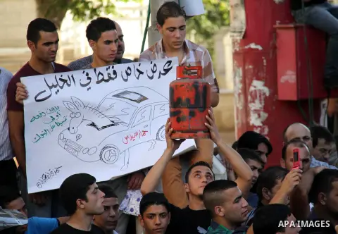 Palestinian protesters wear Guy Fawkes masks as they hold an effigy of Palestinian Prime Minister Salam Fayyad during a protest against the high cost of living, in the West Bank city of Hebron September 4, 2012. The Arab...