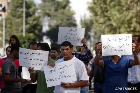 Palestinians hold placards against prime minister Salam Fayyad during a protest against the hight cost of living in the West Bank city of Ramallah on September 4, 2012. Photo by Issam Rimawi